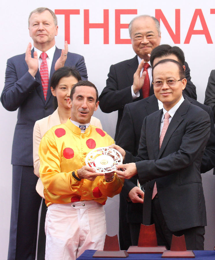 国庆杯颁奖仪式上,中央人民政府驻香港特别行政区联络办公室副主任杨健(右)颁发银碟予胜出马匹”大运财”的骑师杜利莱