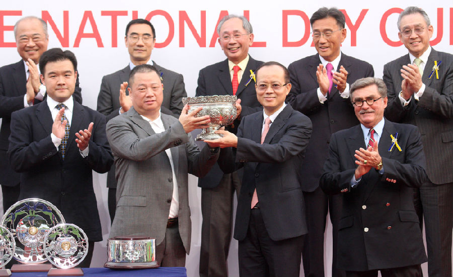 中央人民政府驻香港特别行政区联络办公室副主任杨健(前排右二),将国庆杯的奖杯颁发予胜出马匹”大运财”的马主潘苏通。