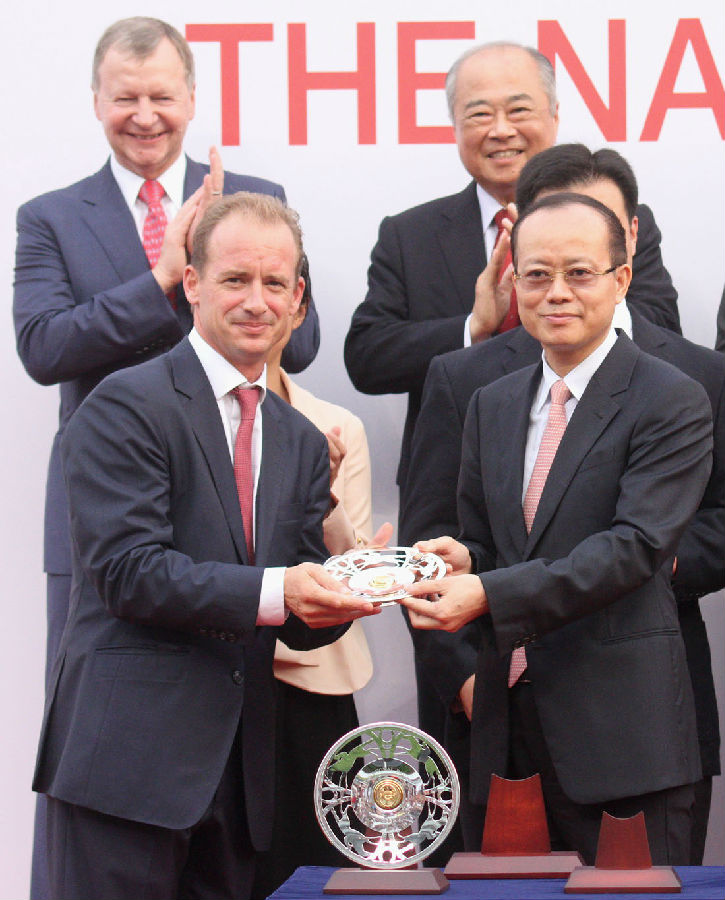 国庆杯颁奖仪式上,中央人民政府驻香港特别行政区联络办公室副主任杨健(右)颁发银碟予胜出马匹”大运财”的练马师高伯新